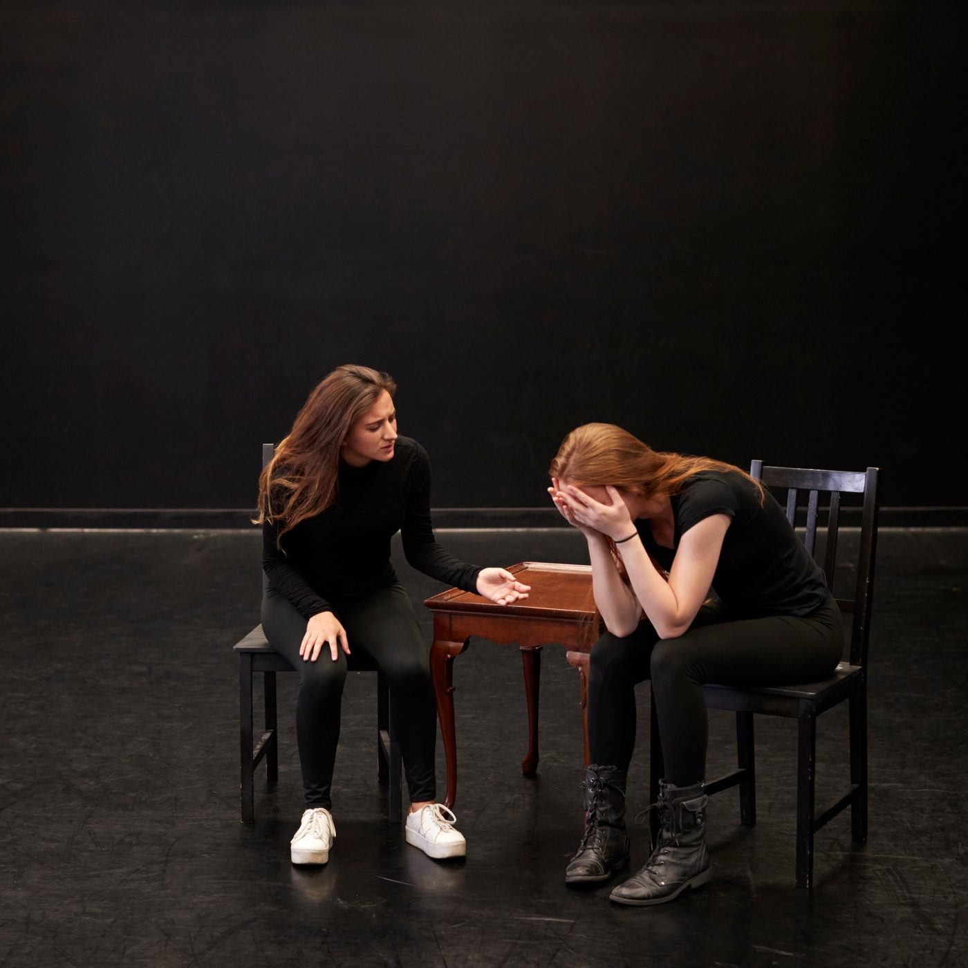 Two performers rehearsing a scene in a black box studio