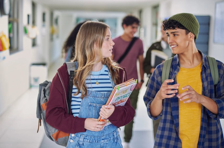 Two teenagers talking in a school corridor